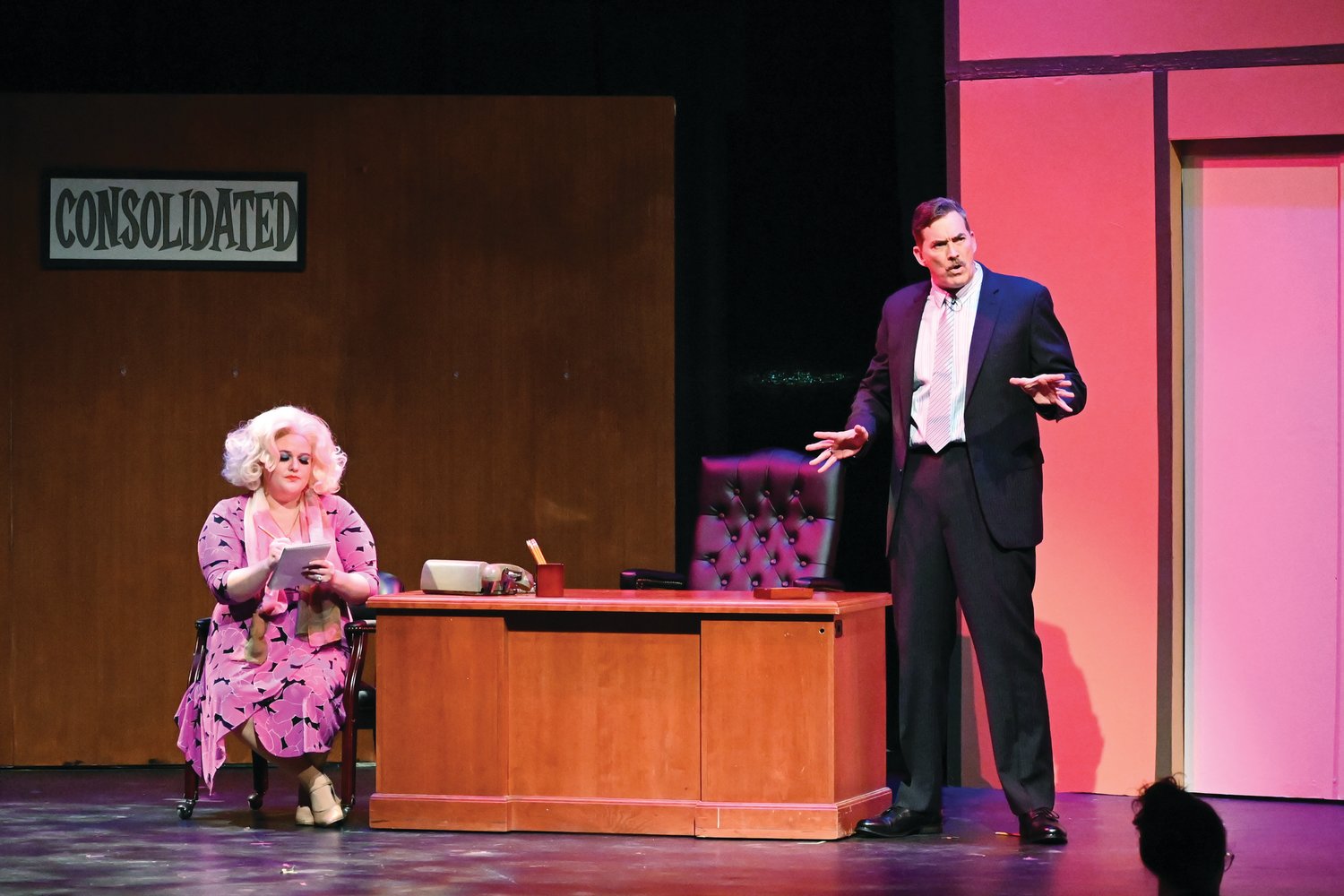 TAKING A MESSAGE: Franklin Hart (played by Ron Martin) dictates a message while secretary Doralee (played by Kaelyn Boss) records what he has to say.